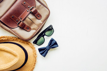 Men's accessories outfits with leather bag, sunglasses, hat, and bow tie, top view, flat lay on...