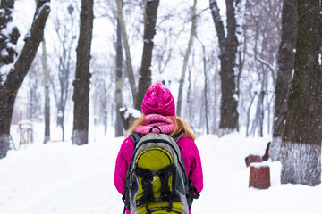 Young happy woman enjoy snow in winter city park outdoor