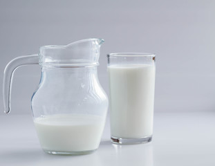 Natural whole milk in a jug and a glass