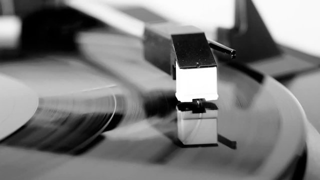 Vinyl record spinning on a turntable, focus on needle