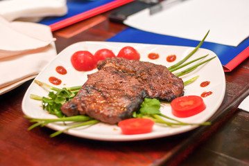 Steak with vegetables on a white plate