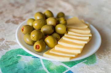 Cheese and olives on a white plate