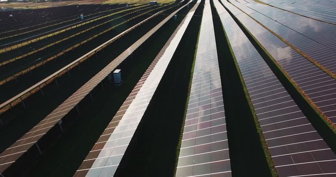 Long rows of photovoltaic panels at a solar farm for converting the energy of the sun to electricity in a concept of renewable energy and natural resources.