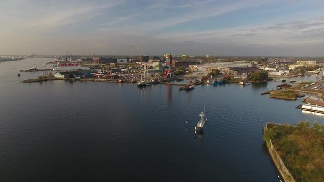 Aerial flying towards Amsterdam North across river IJ, toward hip area in development called the NDSM werf.