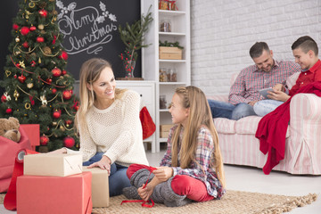 Mother and daughter unwrapping gifts