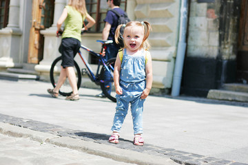 Little smiling girl on city street