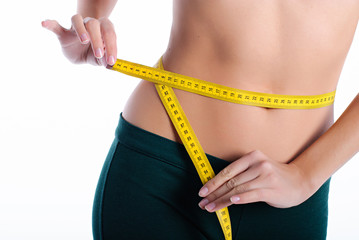 Hands measuring waist with a tape. Slim and healthy woman on white background