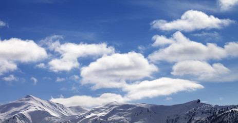 Panoramic view on sunlight snow mountains and blue sky with clou