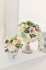 Два маленьких букета из светлых цветов стоят на праздничном столе