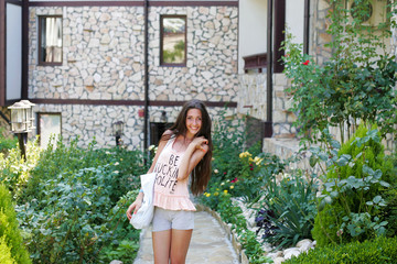 Nice girl stands in a beautiful garden