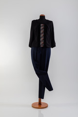 Black blouse with details and blue pants on a mannequin