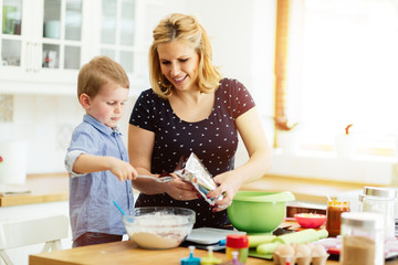 Child helping mother make cookies