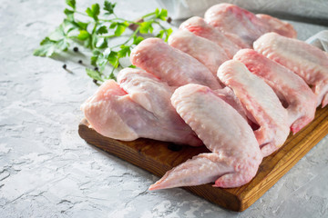 Raw chicken wings on a concrete table with spices