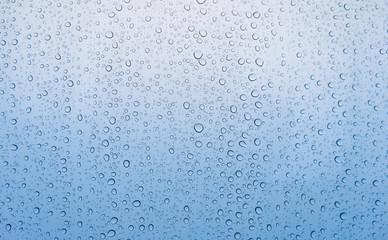 Graduated blue color of drop of rain water on glass