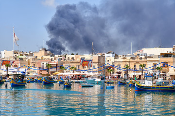 Fototapeta na wymiar The view of fire accident in the Marsaxlokk fishing village, Malta