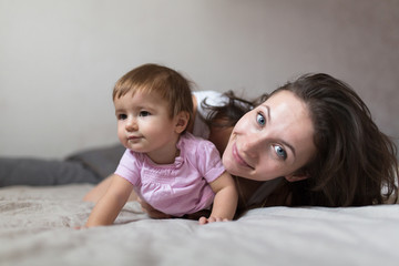 happy loving family. young mother playing with her baby in the b
