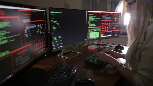Female computer programmer coding, hacking in dark. HD