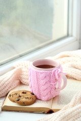 Cup of coffee on windowsill near the window
