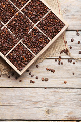Roasted coffee beans in wooden basket on grey table