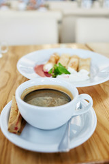cup of coffee and pancakes for breakfast on table