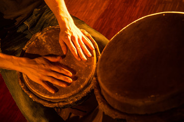 People hands playing music at djembe drums