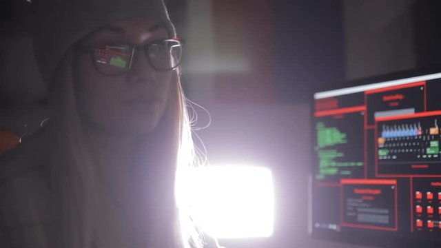 Female computer programmer coding, hacking in dark. HD