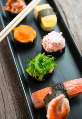 Sushi Set and sushi rolls served on wood table.