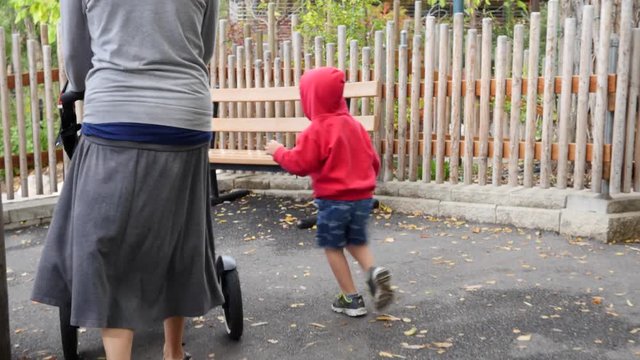 A mother and a boy with stroller at the zoo gimbal shot