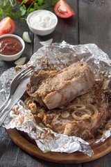 Grilled meat with sauce and vegetables on a dark rustic backgrou