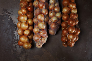 Onions packed in nets hanging on kitchen wall