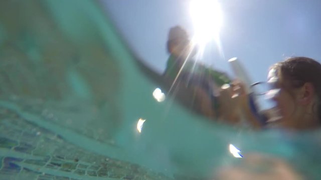 Underwater shot of mother and boy in swimming pool outside
