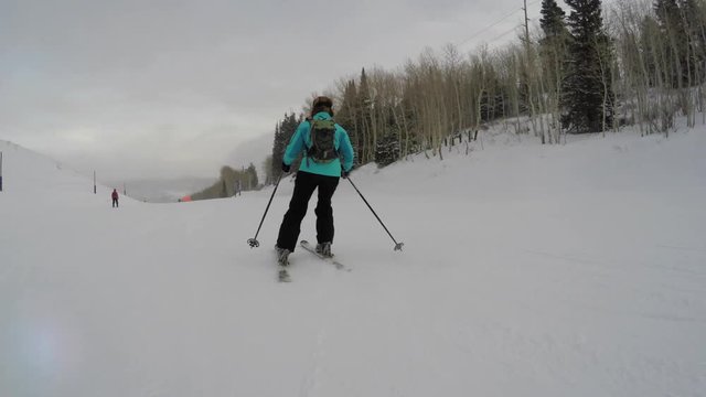 Woman skiing at mountain resort on a cold winter day gimbal shot