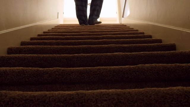 A man walks down house basement stairs