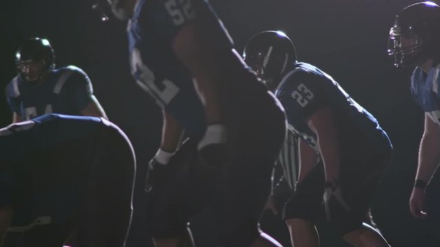 A football player gets past the line and then sacks the quarterback