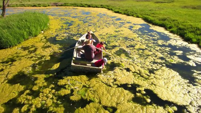 A grandpa with his grand kids in row boat
