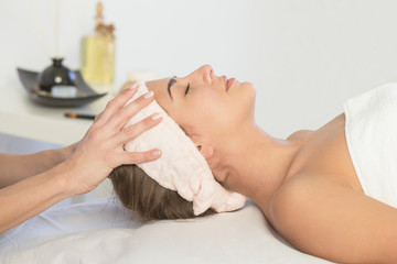 Obraz na płótnie Canvas Young woman enjoying facial massage at spa salon.Facial massage
