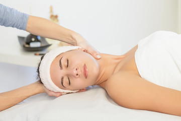 Obraz na płótnie Canvas Young woman enjoying facial massage at spa salon.Facial massage