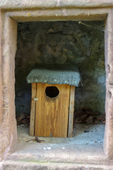 patterned wooden birdhouses stand in a stone cave