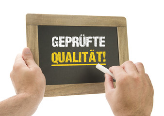 geprüfte Qualität! / Hand schreibt auf Kreidetafel