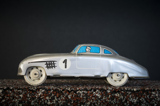 Silver vintage toy car on black background