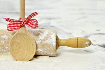 Holiday baking: Rolling-pin and wooden spoon on floured table