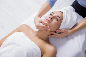 Fototapeta na wymiar Young woman enjoying facial massage at spa salon.Facial massage