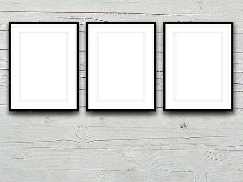 Three Blank Black Picture Frames On Gray Wooden Background