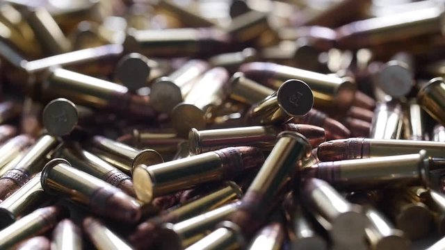 Slow motion of a dolly shot of a pile of .22 ammunition bullets