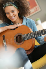 Cheerful girl playing the guitar © goodluz