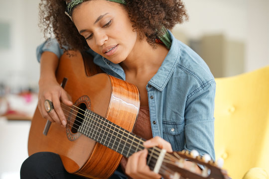 Cheerful girl playing the guitar