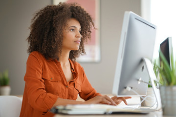 Cheerful businesswoman working on desktop computer - Powered by Adobe