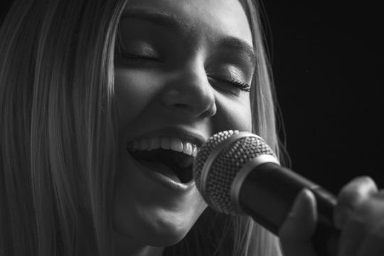 portrait of woman singing into the microphone song