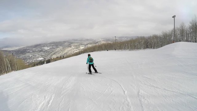A woman skiing down mountain resort hill shot with gimbal