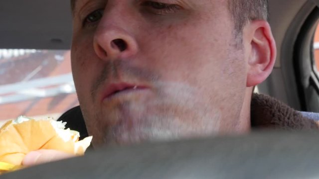 Man eating fast food in the car